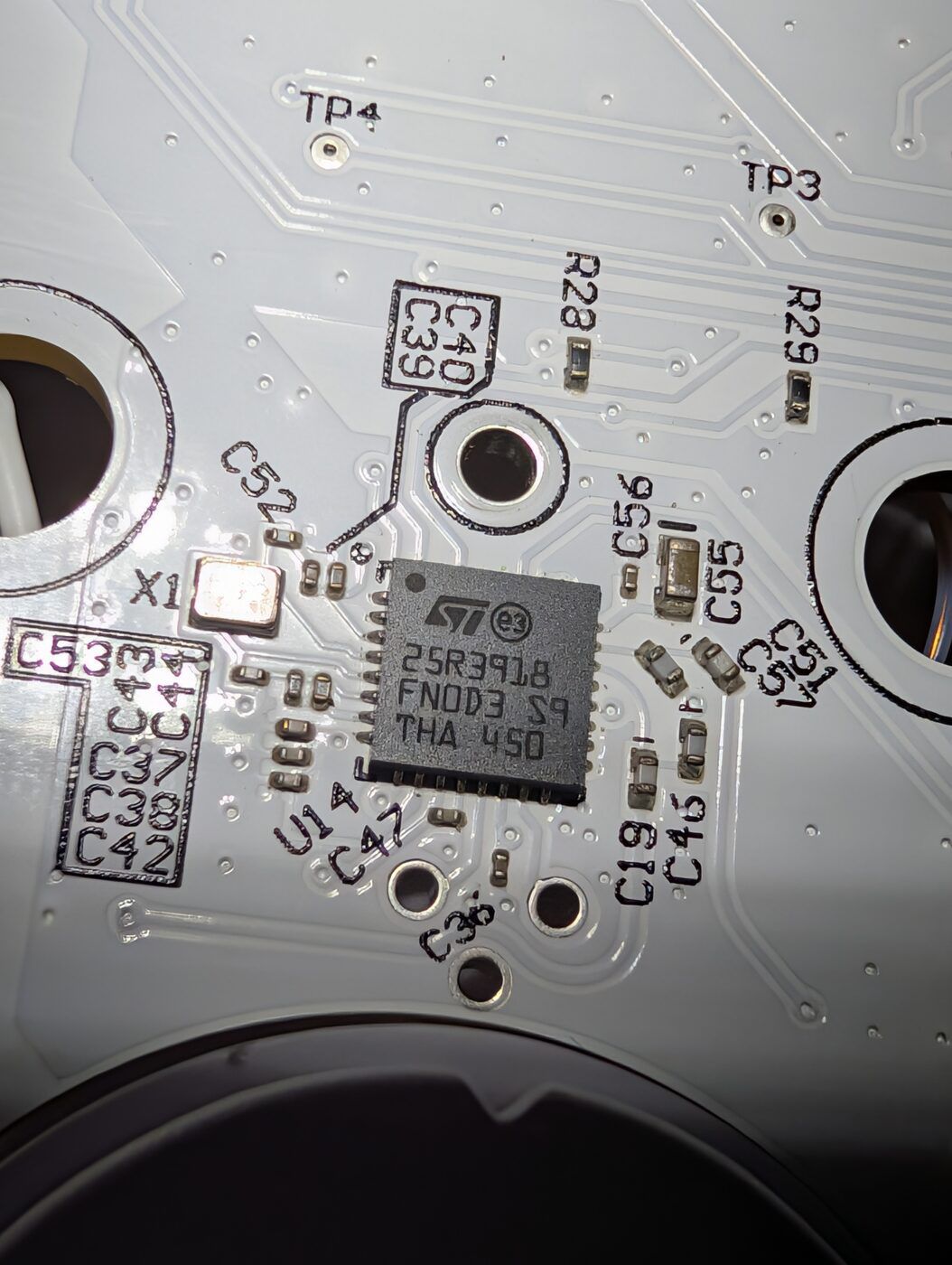 The ST25R3918 (ST logo, 25R3918) — the ISO 15693 front end that reads the cartridge tags, X1 clock crystal beside it. One reader, and on the two-bay boards it has to service both antennas.
