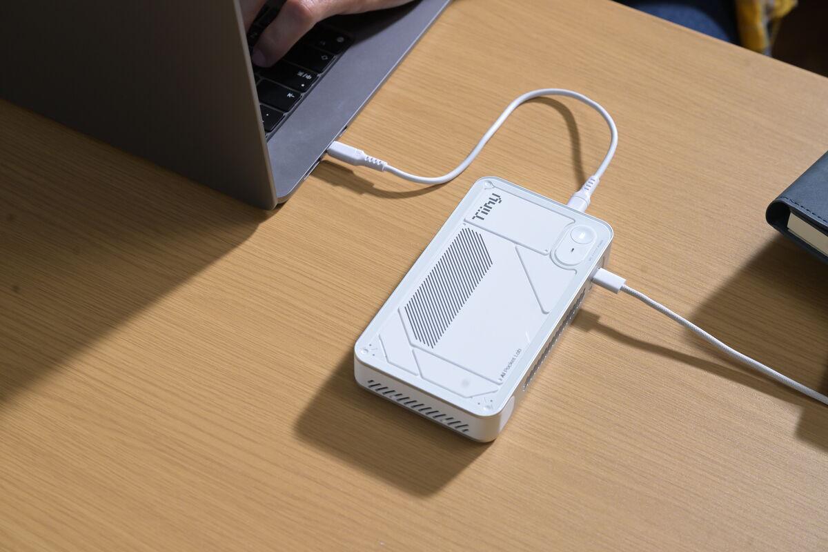 TiinyAI Pocket Lab on desk connected to laptop via USB-C with separate power cable